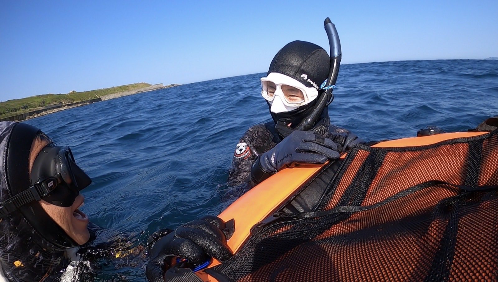 Freedivers and a surface safety float in open water